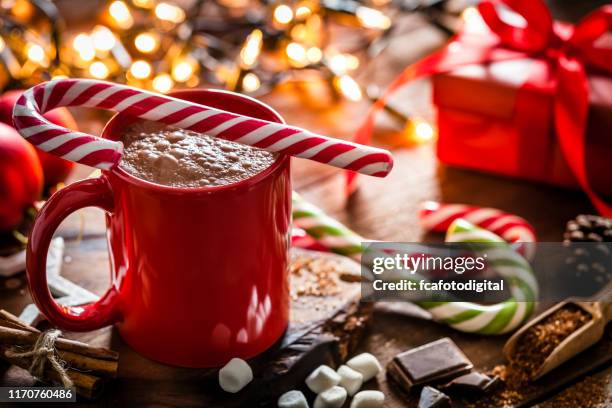 hausgemachte heiße schokolade becher mit roten und weißen zuckerrohr auf rustikalen holz weihnachtstisch - punsch tasse stock-fotos und bilder