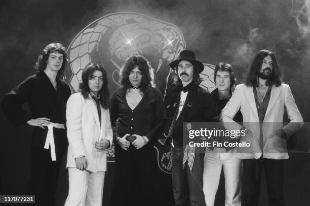 Whitesnake , British rock band, pose standing in front of the band's snake logo for a group studio portrait in Camden, London, England, Great...