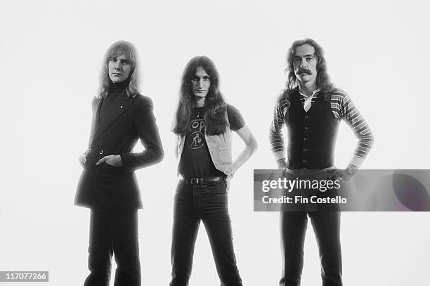 Guitarist Alex Lifeson, bassist and singer Geddy Lee and drummer Neil Peart), Canadian rock band, pose, against a white background, for a group...