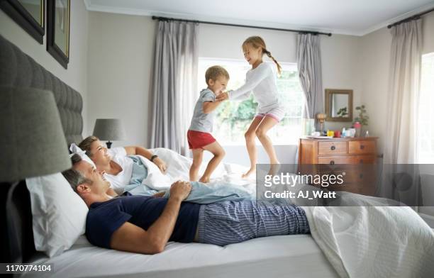 kinder springen gerne aufs bett - children jumping bed stock-fotos und bilder