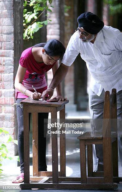 Student fill up admission form with the help her Father at the North campus of the Delhi University on June 20,2011.