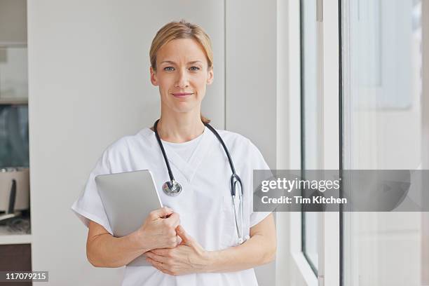 nurse or doctor in scrubs with digital tablet - uniforme hospitalar imagens e fotografias de stock
