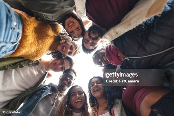 multiethnische gruppe von universitätsstudenten mit blick nach unten - soziales engagement stock-fotos und bilder