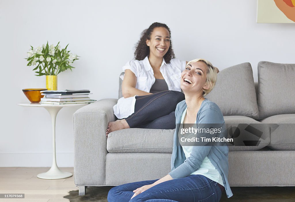 Two women in modern living room, smiling