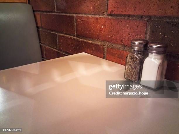 salt and pepper shaker on a restaurant table. - salt shaker stockfoto's en -beelden