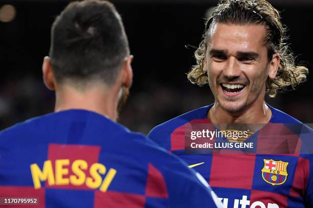 Barcelona's French forward Antoine Griezmann is congratulated by teammate Barcelona's Argentine forward Lionel Messi after scoring the first goal...