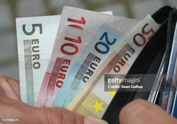 In this photo illustration a man removes Euro currency bills from a wallet on June 21, 2011 in Berlin, Germany. Eurozone finance ministers are...