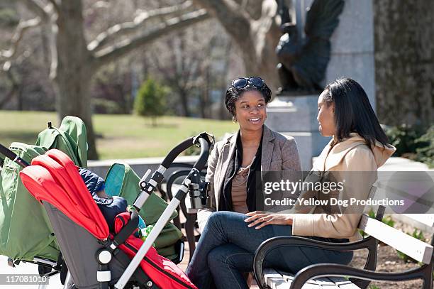 two moms with babies and strollers in the park - baby pram in the park stock pictures, royalty-free photos & images