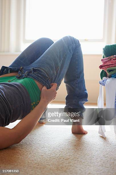 young woman putting on jeans - 超小號 個照片��及圖片檔