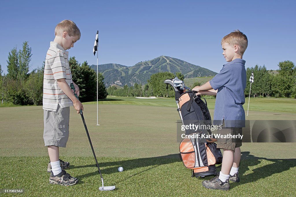 Two young boys golfing