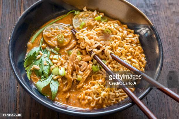 ramen soup with peanut sauce and chicken - ramen noodles stock pictures, royalty-free photos & images