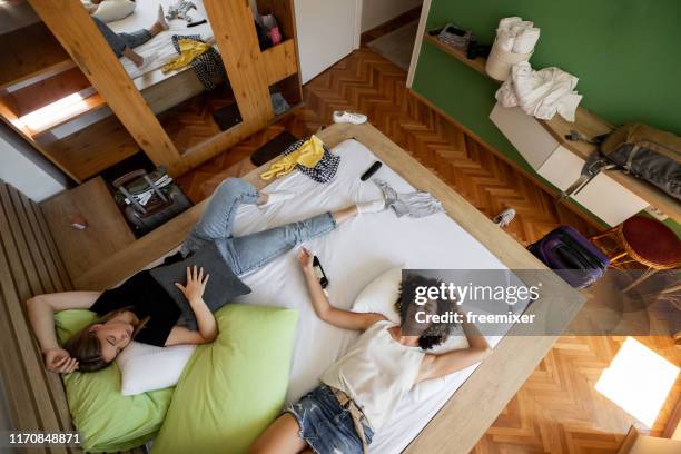 dos mujeres borrachas durmiendo en la cama con una botella de whisky - morning after party fotografías e imágenes de stock