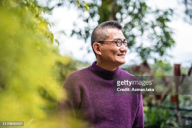 portrait of smiling mature chinese man in outdoor setting - mature men stock pictures, royalty-free photos & images