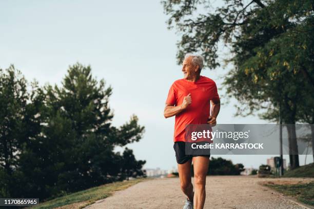 senior retired man runs and performs exercise - active seniors running stock pictures, royalty-free photos & images