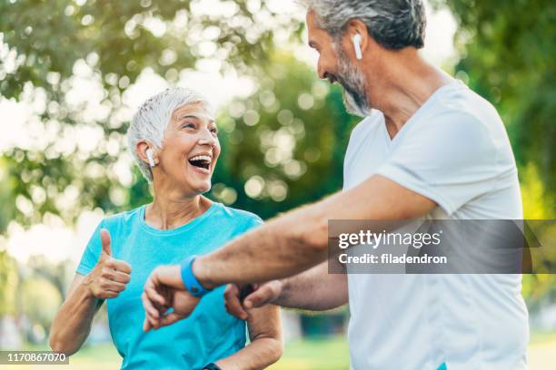 senior couple using sports technologies - pedometer stock pictures, royalty-free photos & images
