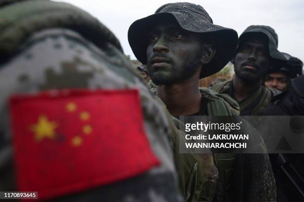 In this photo taken on September 23, 2019 shows a Chinese soldier standing with Sri Lankan military personnel during a training exercise on the...