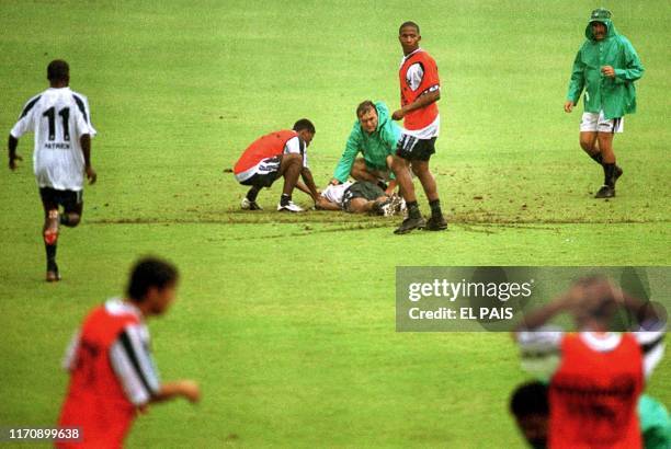 Players of Deportivo Cali aid their teammate Herman Gaviria after he was reportedly struck by lightening 24 October during a practice in Cali,...