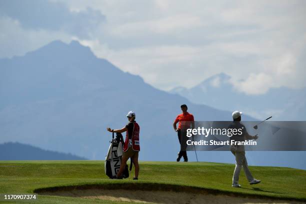 Lee Westwood of England reacts after playing a shot on the seventh as caddie Helen Storey and Rory McIlroy of Northern Ireland look on during Day One...
