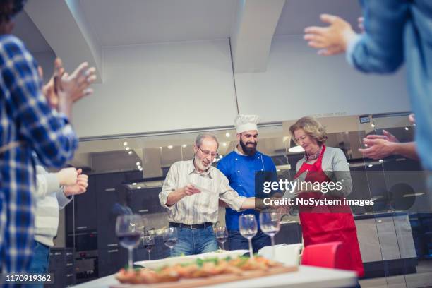 chef announcing the winners for the best prepared meal on cooking class - awards party 2018 stock pictures, royalty-free photos & images