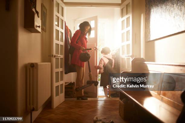 a mother and daughter leaving the house. - zwart jak stockfoto's en -beelden