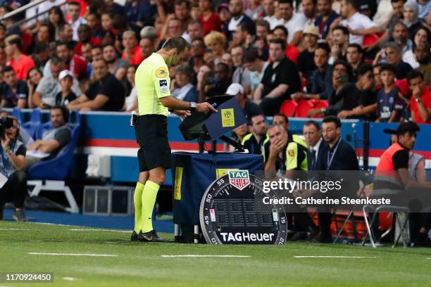 The referee Jerome Brisard is looking at the VAR during the Ligue 1 match between Paris Saint-Germain and Toulouse FC at Parc des Princes on August...