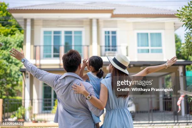 a happy family walking home - buy house stock pictures, royalty-free photos & images