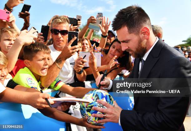 Lionel Messi of FC Barcelona signs autographs for fans as he arrives on the red carpet prior to the UEFA Champions League Draw, part of the UEFA...