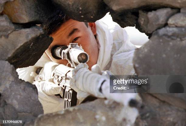 Russian sniper takes aim at Chechen fighters from a position in the village of Sergen-Yurt, south-east from Grozny, 25 January 2000. Chechens...