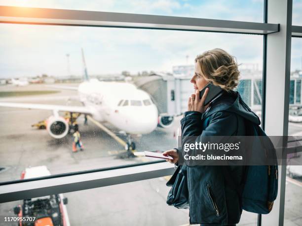 woman waiting for her flight in airport lounge - getting on stock pictures, royalty-free photos & images