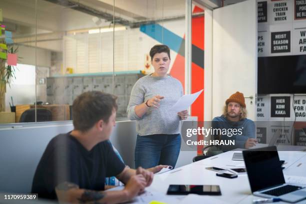 weibliche zeitungsredakteurin diskutiert mit kollegen - press conference stock-fotos und bilder