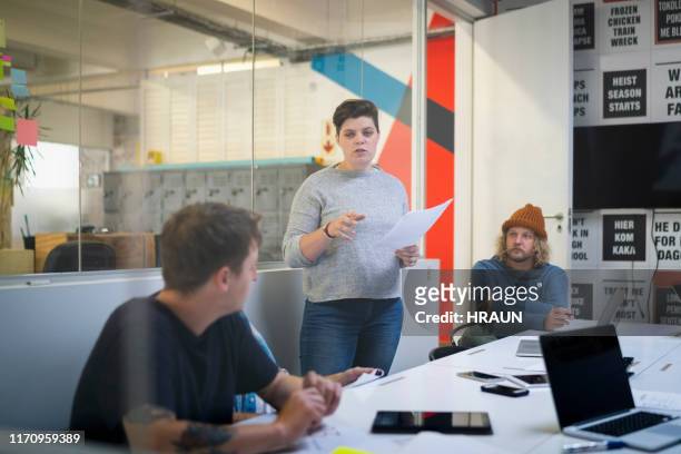 female newspaper editor discussing with colleagues - press conference stock pictures, royalty-free photos & images