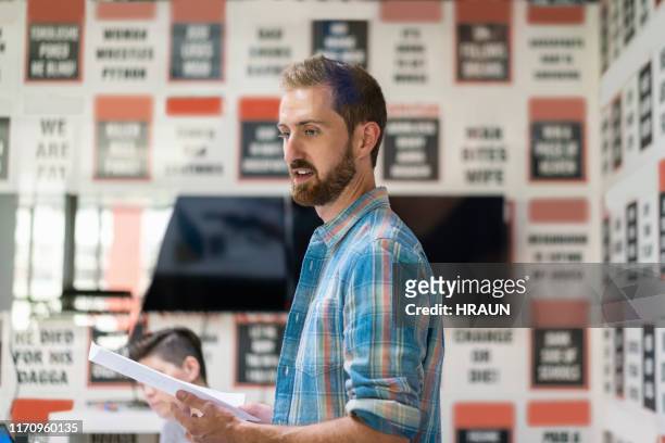 young male editor holding document in board room - press conference reporters stock pictures, royalty-free photos & images