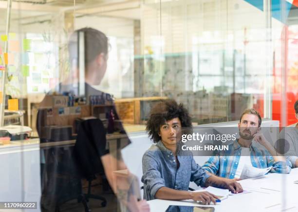 young journalists looking at colleague in meeting - pressroom stock pictures, royalty-free photos & images