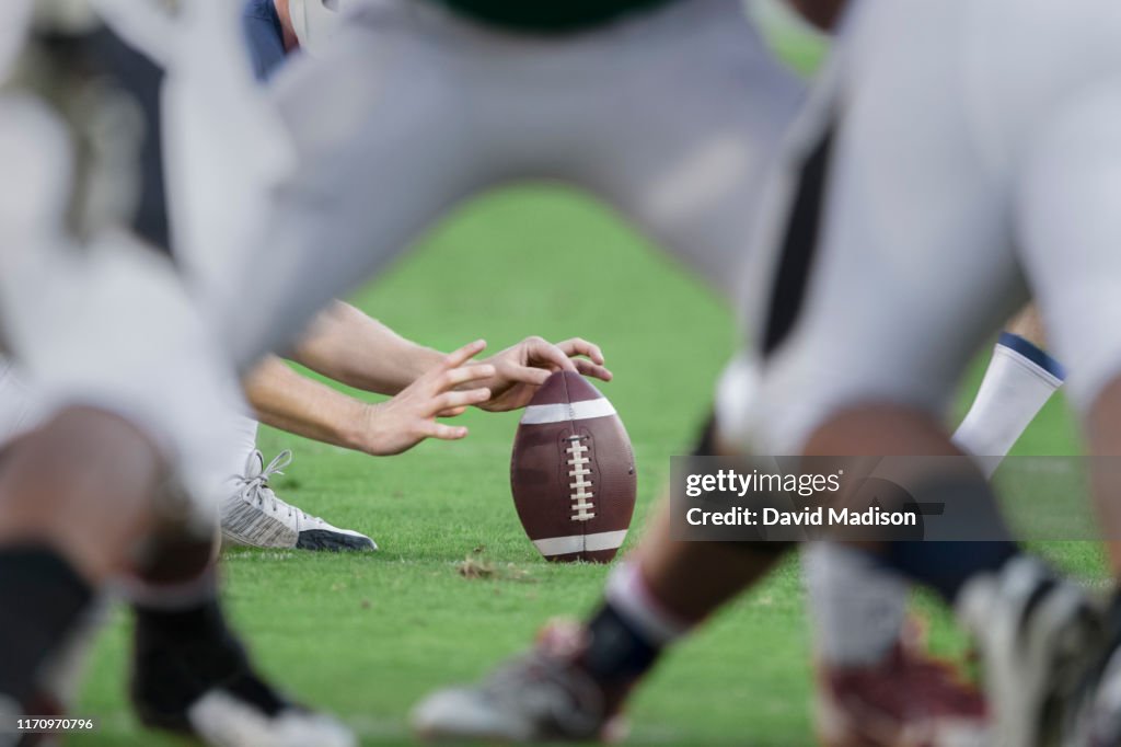 American football players readying to kick ball