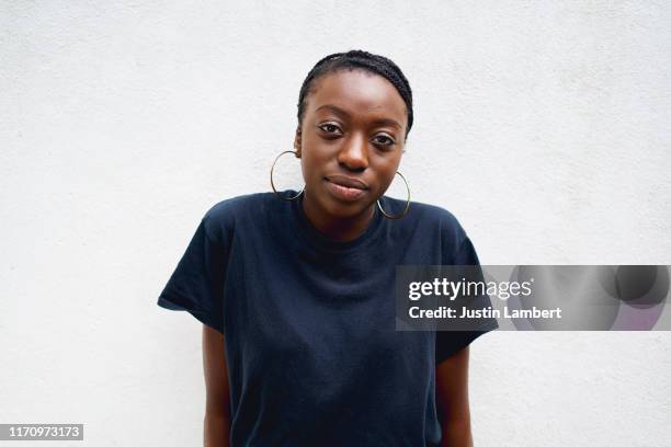 confident woman with attitude looking at camera laughing shot against white wall - female exhibitionist ストックフォトと画像