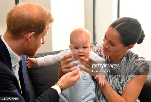 Prince Harry, Duke of Sussex and Meghan, Duchess of Sussex tend to their baby son Archie Mountbatten-Windsor at a meeting with Archbishop Desmond...