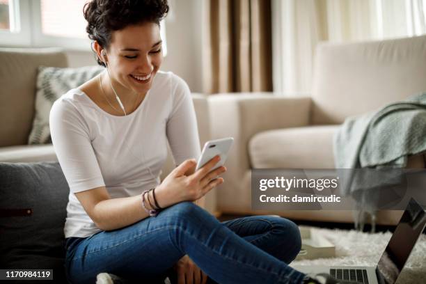 lachende jonge vrouw ontspannen thuis - texting at work stockfoto's en -beelden
