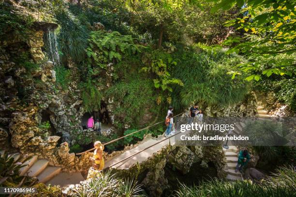 tourists explore cascade lake in quinta da regaleira in sintra, portugal - sintra portugal stock pictures, royalty-free photos & images