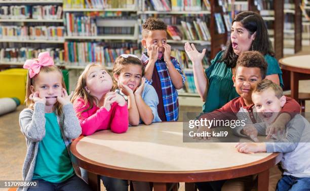 hispanic teacher, elementary school children in library - naughty kids in classroom stock pictures, royalty-free photos & images