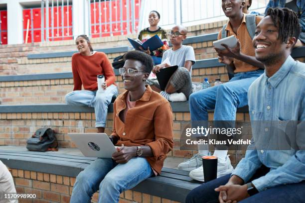 smiling multi-ethnic students enjoying at campus - man lady phone ipad outside stock pictures, royalty-free photos & images