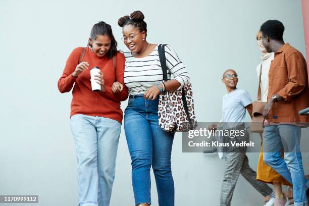 smiling female students walking against friends - student fashion stock pictures, royalty-free photos & images