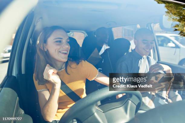 happy young woman dancing with friends in car - zingende man stockfoto's en -beelden
