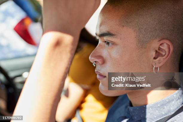 close-up side view of young male hipster in car - ohrring stock-fotos und bilder