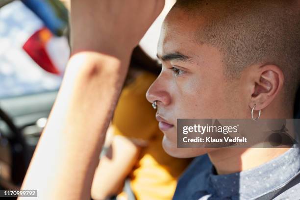 close-up side view of young male hipster in car - oorbellen stockfoto's en -beelden