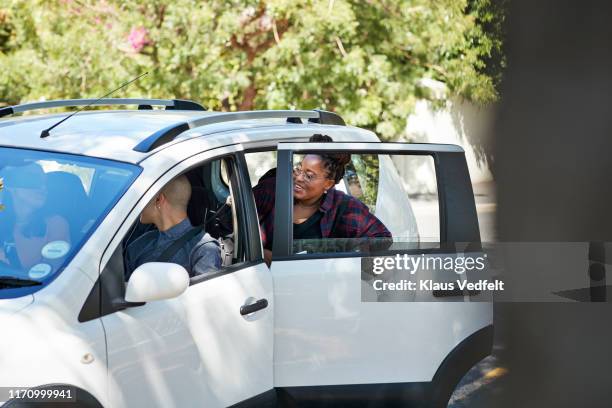 female student opening door and entering car - car pooling stock pictures, royalty-free photos & images