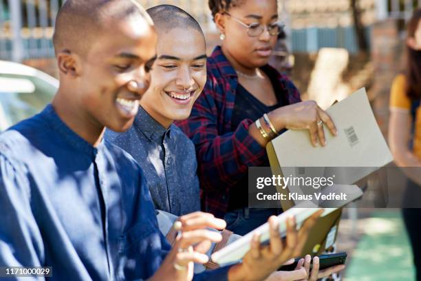 smiling male students sharing digital tablet - male student wearing glasses with friends stock-fotos und bilder