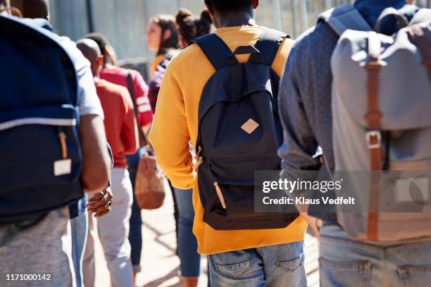 male and female adult students walking at campus - student backpack stock pictures, royalty-free photos & images