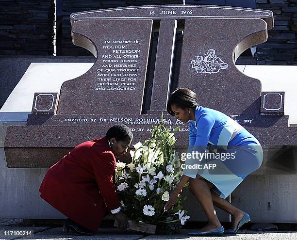 First Lady Michelle Obama and Antoinette Sithole, the sister of Hector Pieterson, a 12-year-old boy killed during the student uprising in protest at...