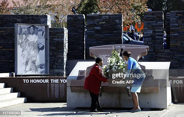 First Lady Michelle Obama and Antoinette Sithole, the sister of Hector Pieterson, a 12-year-old boy killed during the student uprising in protest at...