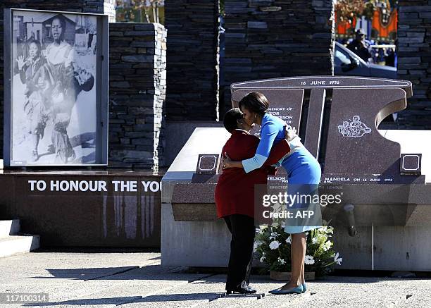 First Lady Michelle Obama and Antoinette Sithole, the sister of Hector Pieterson, a 12-year-old boy killed during the student uprising in protest at...